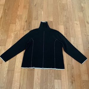 Plus size woman’s black turtleneck.